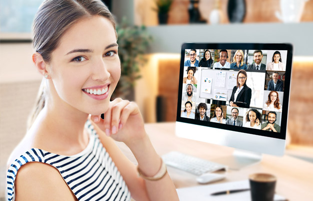 Frau am Laptop in Online Konferenz mit mehreren Teilnehmern.